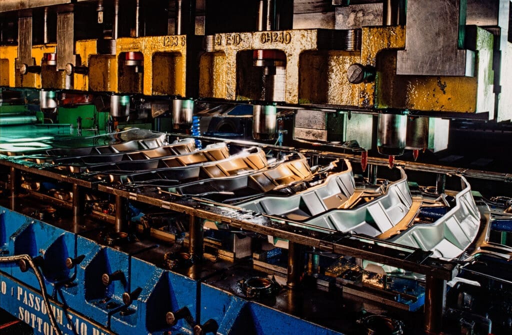 Automotive metal stamping done in a factory.