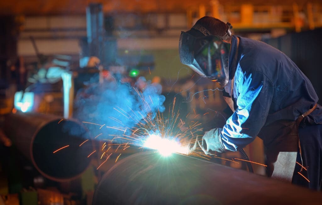 A person welding a large diameter pipe