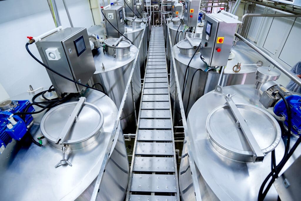 Equipment at modern dairy plant with stainless tanks.