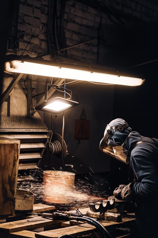 A guy working on fabrication process with grinder
